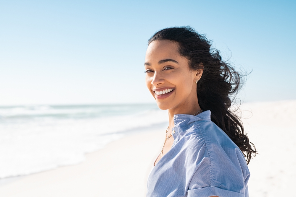 woman smiling at the beach.