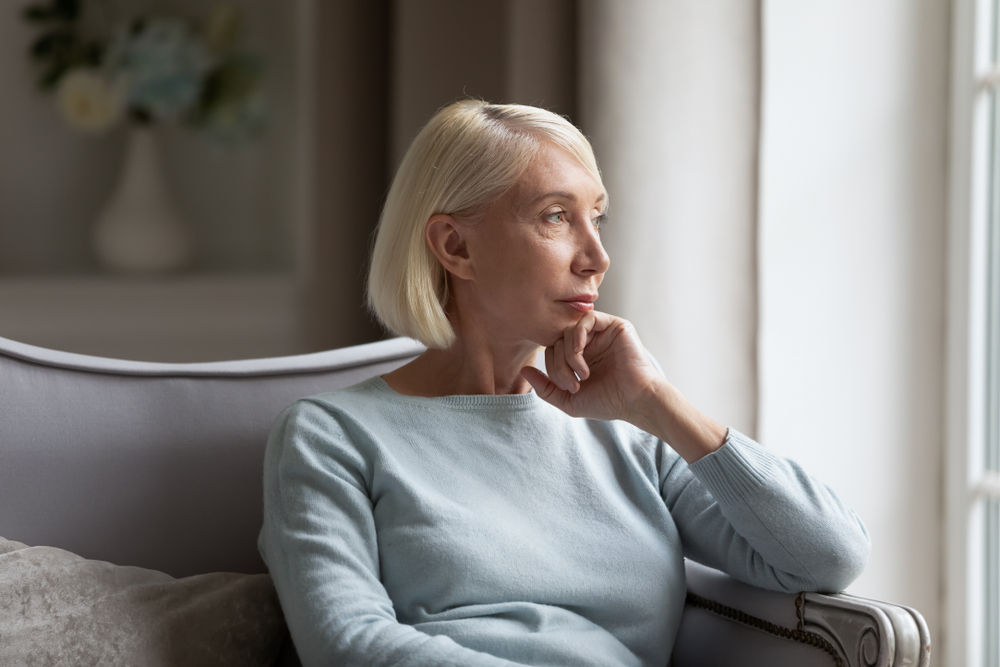 older woman looking out window.